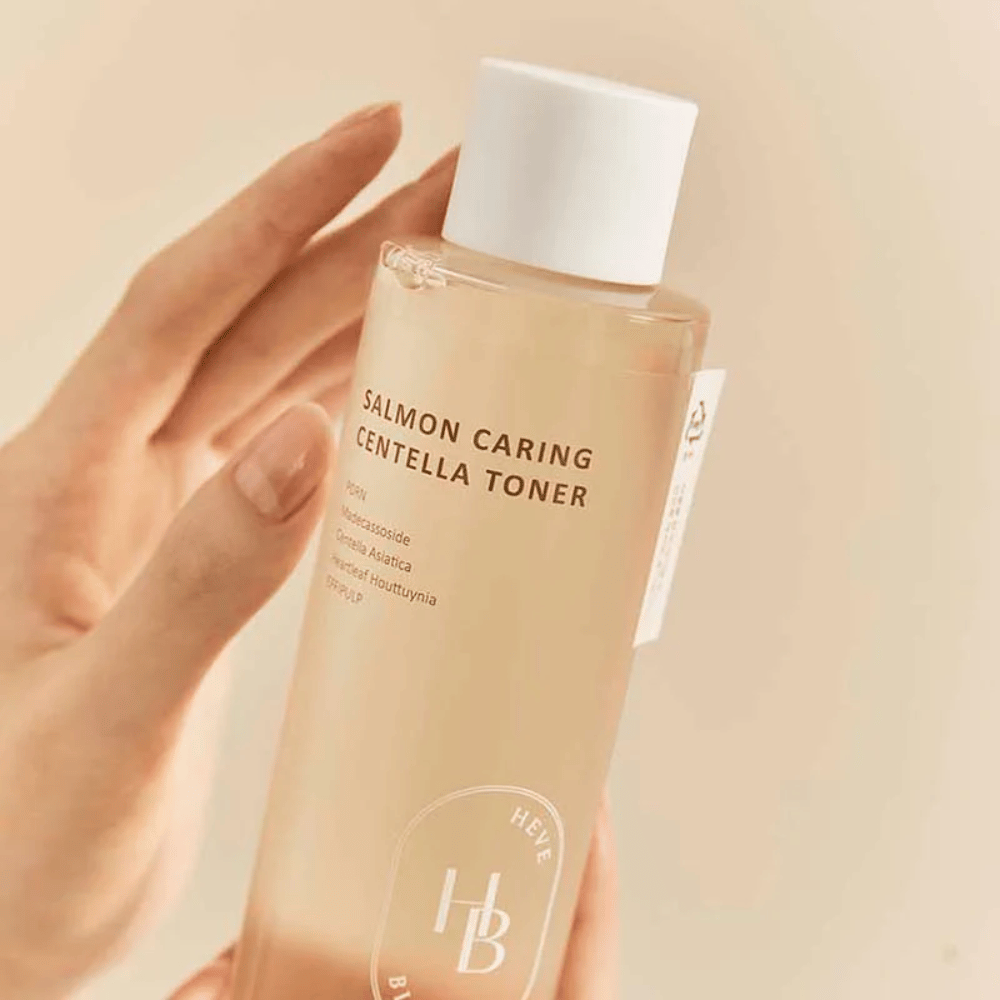 Close-up de Salmon Caring Centella Toner na mão – toner calmante com PDRN e extrato de plantas que ajuda a fortalecer a pele e reduzir a sensação de irritação.