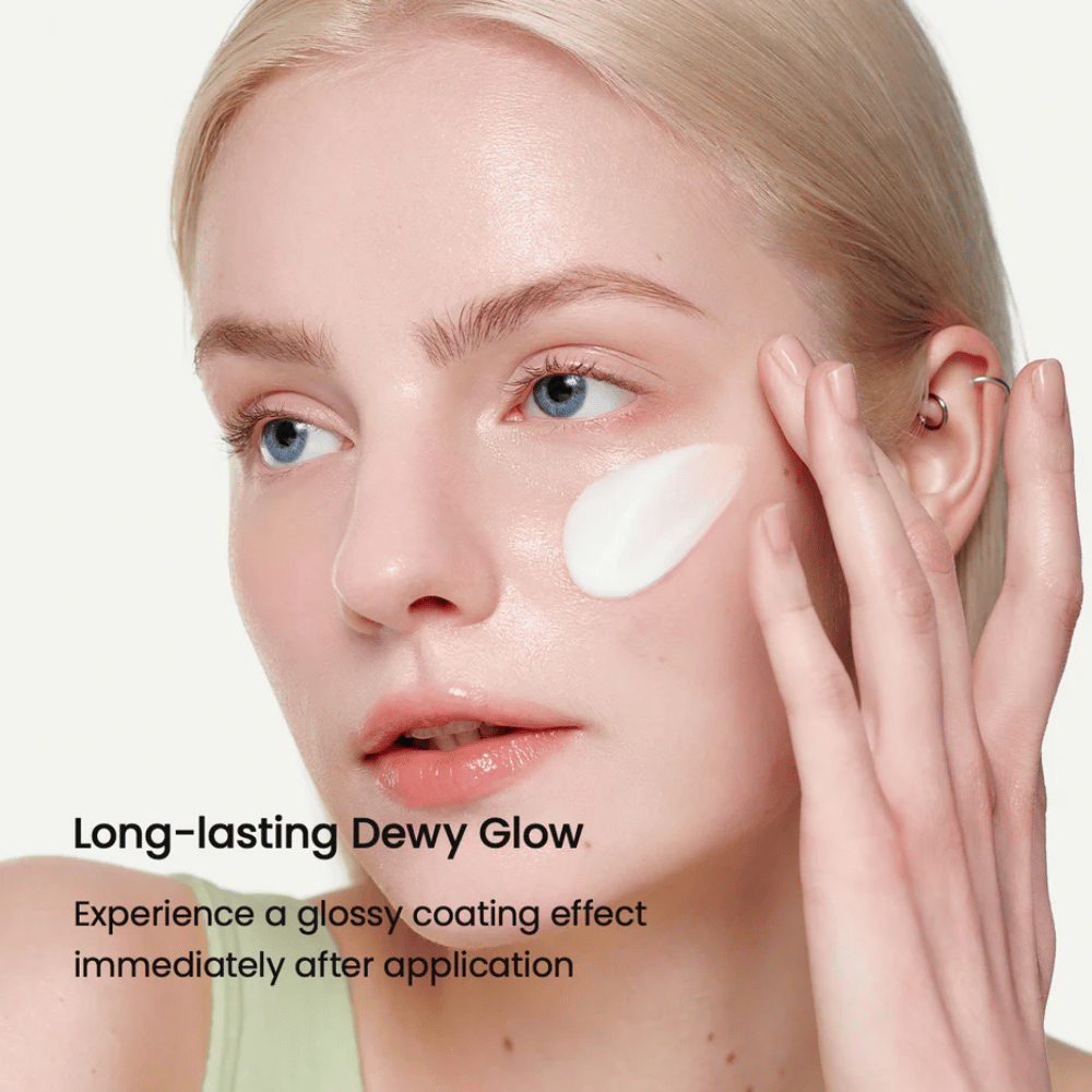 Close-up de uma mulher de pele clara aplicando Biodance Skin-Glow Essence Cream na bochecha, proporcionando uma aparência imediatamente brilhante e hidratada com um brilho duradouro.