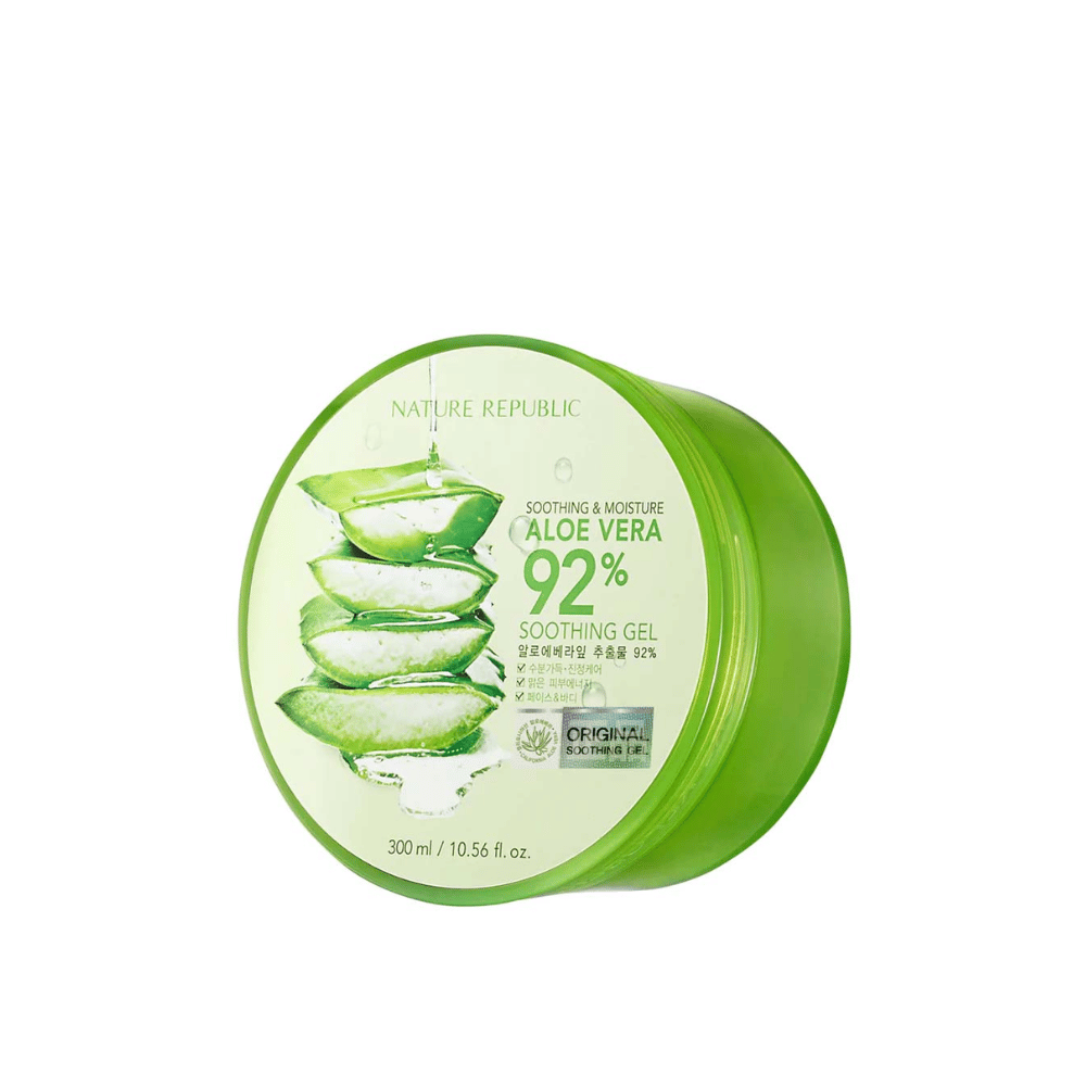 Uma lata redonda verde com Nature Republic Aloe Vera 92% Gel Suavizante. A embalagem mostra uma imagem de folhas de aloe vera e texto que descreve as propriedades calmantes e hidratantes do produto. O conteúdo é de 300 ml (10.56 fl. oz).