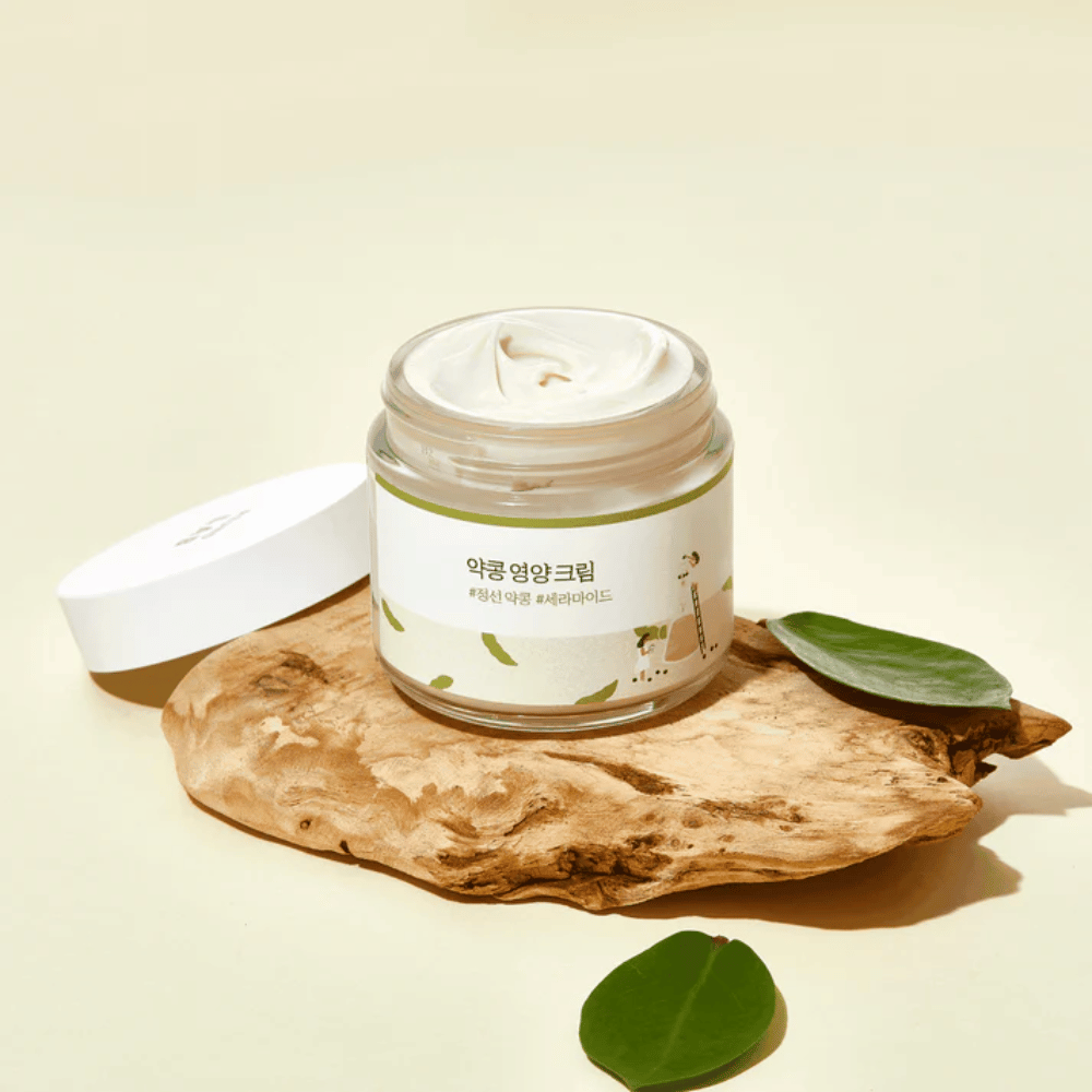 Mixsoon Soybean Nourishing Cream em frasco aberto sobre uma peça de madeira com folhas verdes. Um creme nutritivo com soja fermentada e ceramidas.
