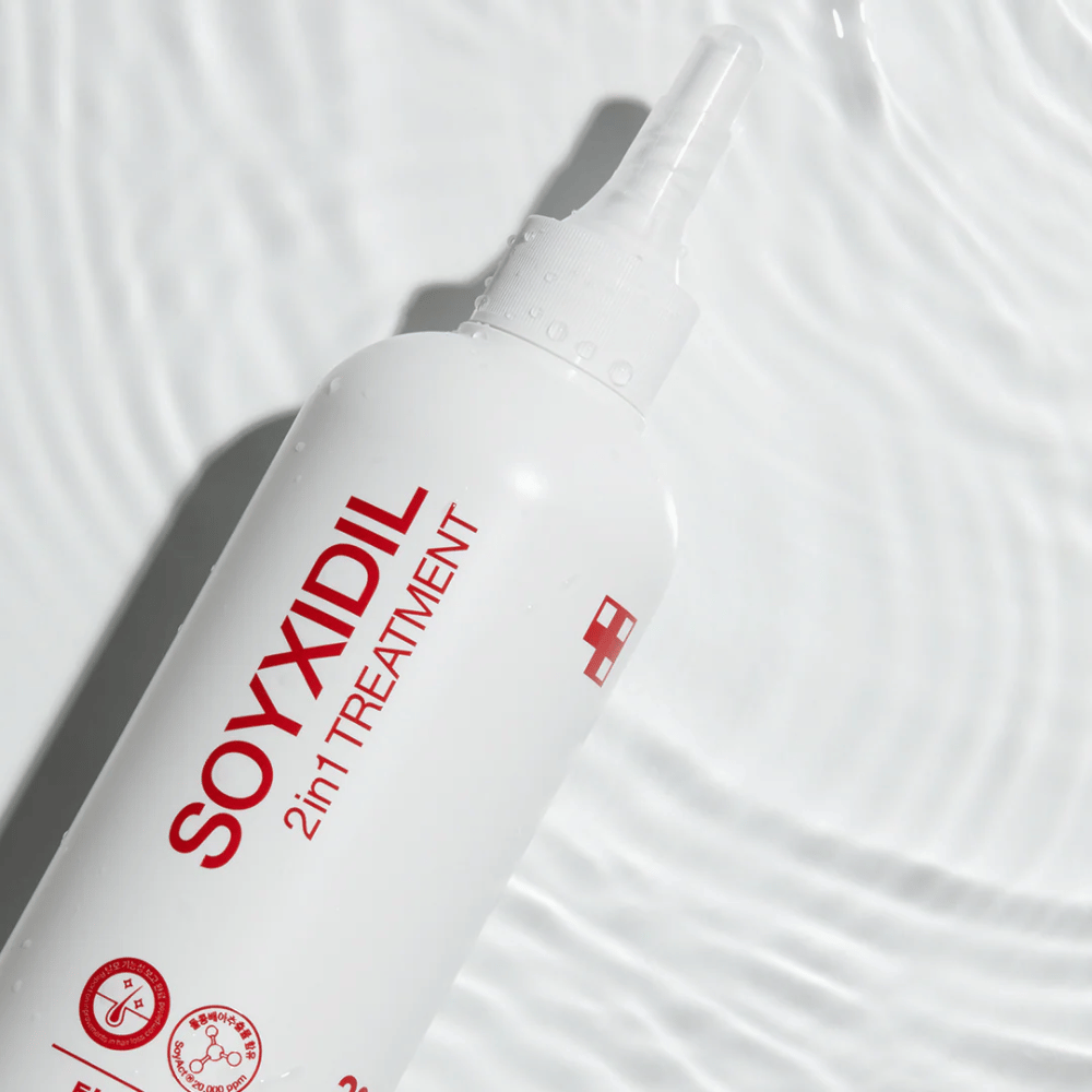 Garrafa de Medicube Soyxidil 2in1 Treatment repousa sobre uma superfície de água ondulada, simbolizando cuidado hidratante e refrescante.