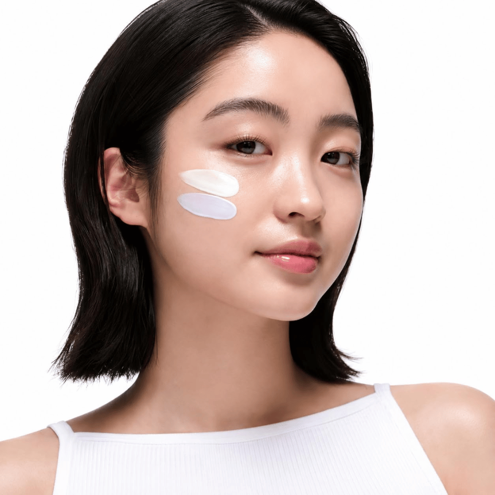 2. Beauty of Joseon Stay Fresh Color Correcting Sunscreen SPF 50 – modelo com protetor solar corretor de cor verde e roxo na bochecha
