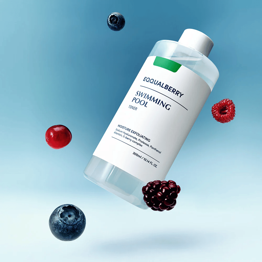 Equalberry Swimming Pool Toner em uma garrafa elegante flutuando contra um fundo azul, cercada por frutas frescas como mirtilos, framboesas e amoras.
