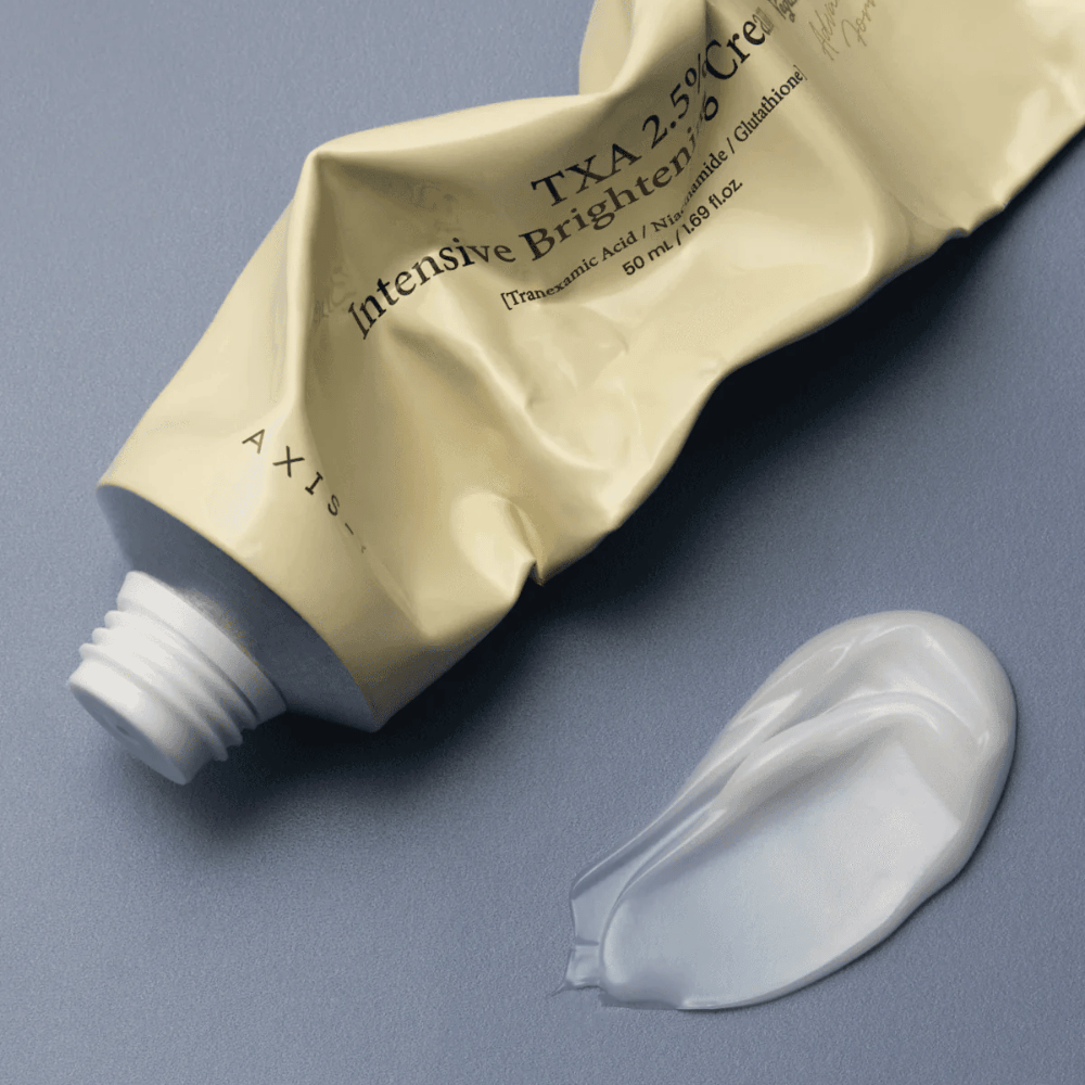 Imagem do produto com a bisnaga e uma pequena porção de creme ao lado para mostrar a textura suave e cremosa e a fórmula hidratante. O foco está no glow e na aplicação uniforme.