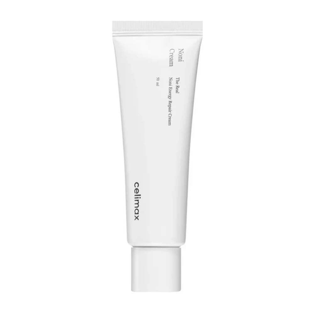 Celimax Noni Energy Repair Cream em um tubo branco com texto preto. O produto é marcado como "The Real Noni Energy Repair Cream" e tem um volume de 50 ml.