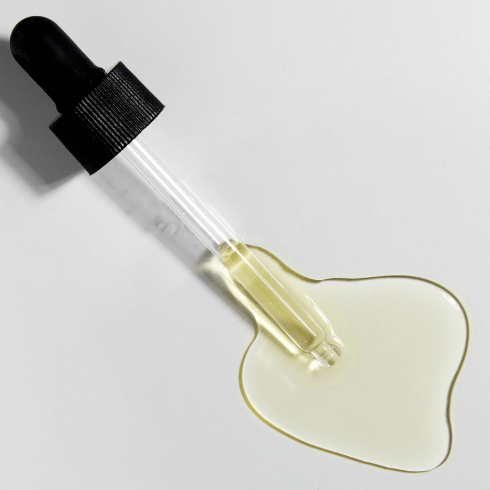 Close-up de pipeta com COSRX The Vitamin C 13 Serum e fórmula dourada de vitamina C, sérum concentrado com vitamina E e ácido hialurônico.