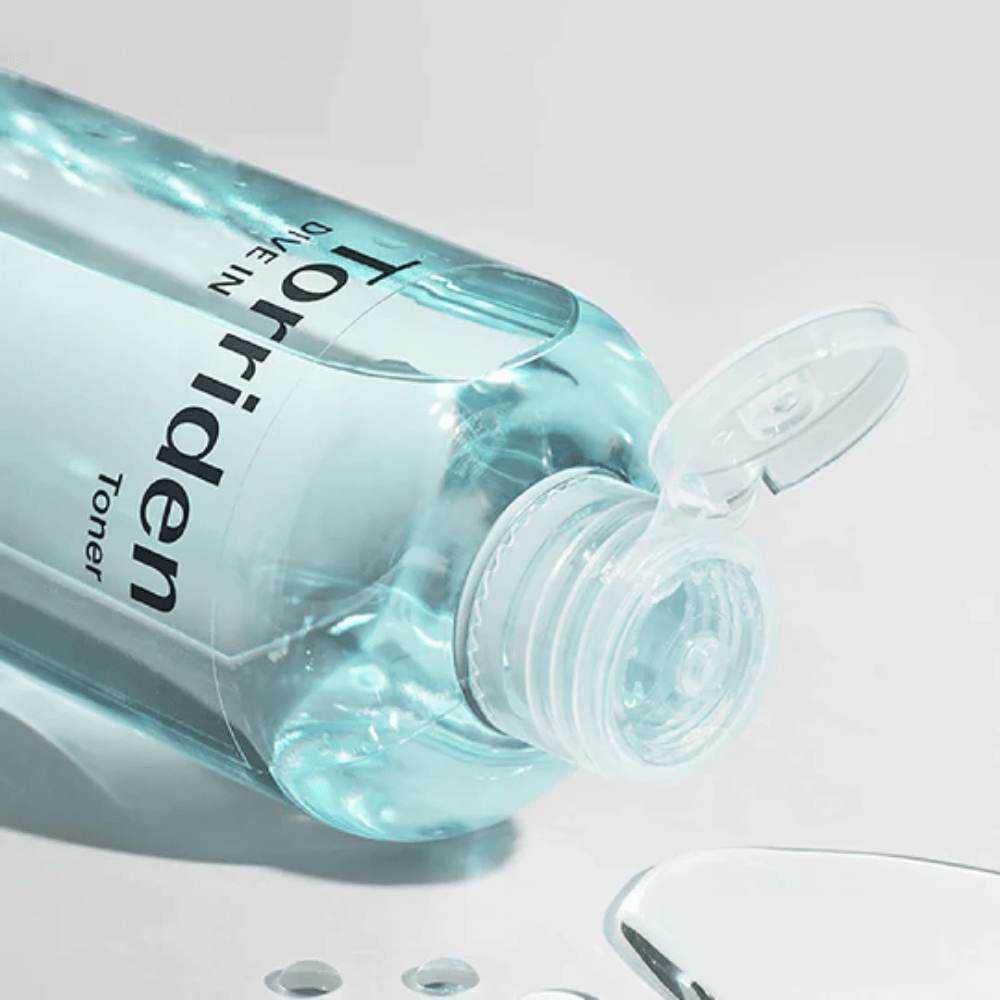 Uma garrafa DIVE-IN Low Molecule Hyaluronic Acid Toner 300ml ao lado de um copo de água, promovendo Torriden e hidratação.