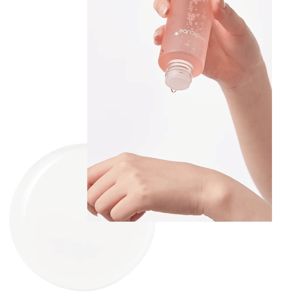Mão aplicando Medicube Triple Collagen Toner 4.0 de uma garrafa rosa na pele, mostrando a consistência hidratante.