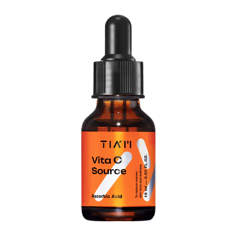 TIA'M Vita C Source, um sérum com ácido ascórbico em frasco de vidro castanho com pipeta preta e rótulo laranja – eficaz para iluminar a pele e reduzir o tom de pele irregular.