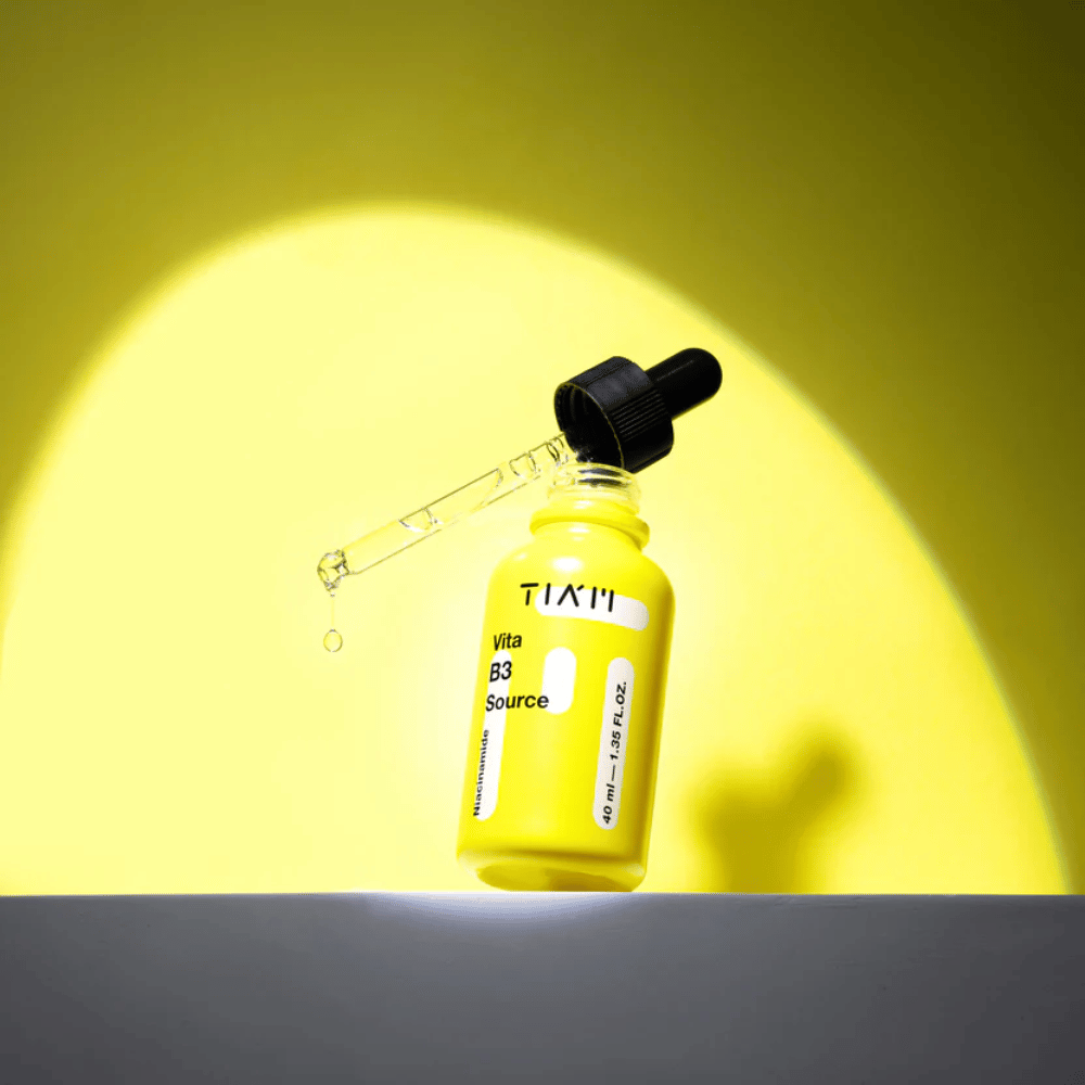 TIA'M Vita B3 Source – sérum de niacinamida em garrafa amarela com pipeta, projetado para iluminar a pele e proporcionar um tom de pele mais claro.
