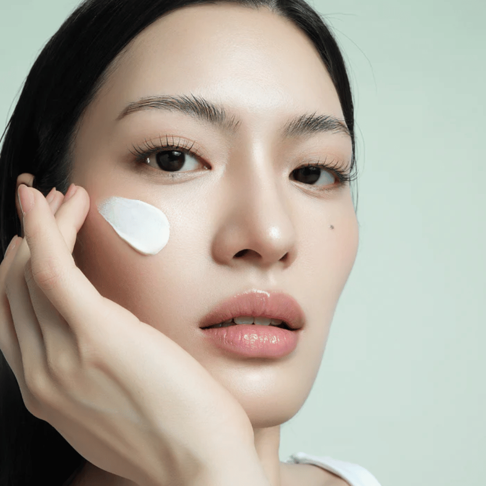 Modelo aplica d’Alba Waterfull Mild Sun Cream SPF 50+ no rosto. Proteção solar leve e hidratante com filtro mineral, perfeito para uso diário e pele sensível.