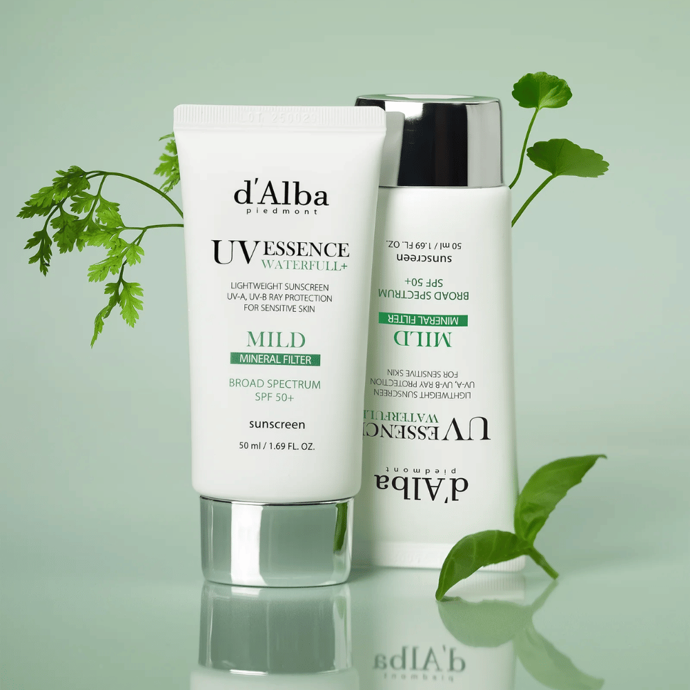 d’Alba Waterfull Mild Sun Cream SPF 50+ fotografado com folhas verdes. Creme solar suave à base de minerais com proteção de amplo espectro e fórmula hidratante para pele sensível.