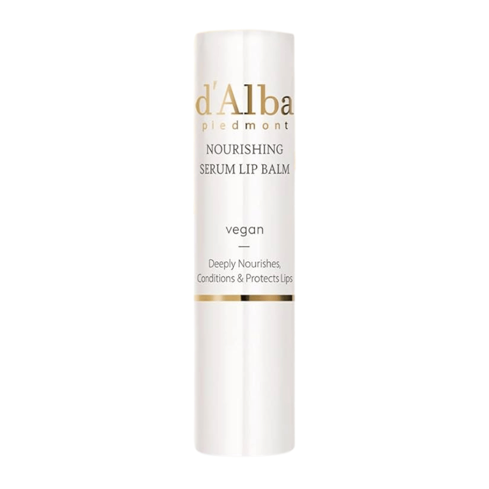 Imagem do produto d'Alba Nourishing Serum Lip Balm em embalagem branca e dourada com o texto "vegan" e "Deeply Nourishes, Conditions & Protects Lips".