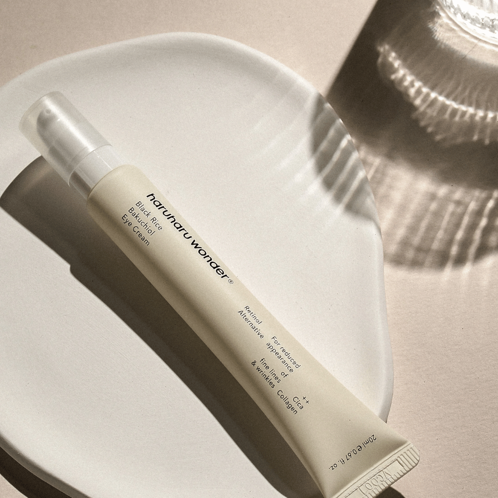 HaruHaru Wonder Black Rice Bakuchiol Eye Cream 20 ml – creme para os olhos com arroz preto, bakuchiol e colágeno que reduz linhas finas e rugas, colocado em prato de cerâmica em luz suave.