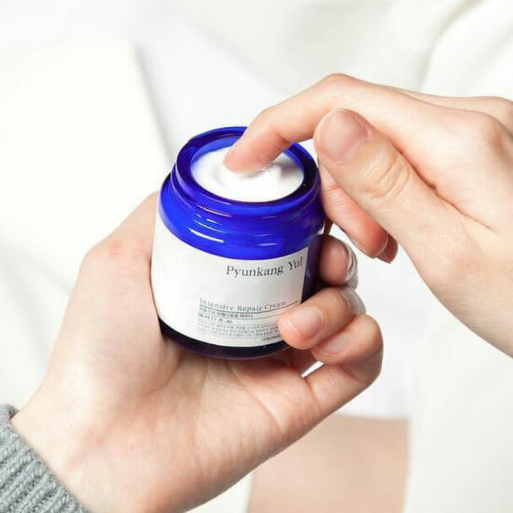 Uma pessoa segura um frasco Pyunkang Yul Intensive Repair Cream 50ml.