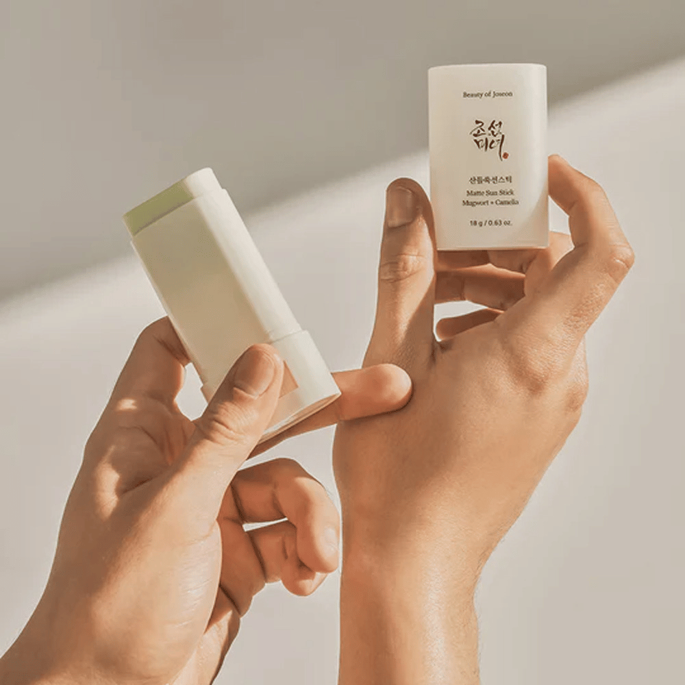 Duas mãos segurando um bastão do Beauty of Joseon's Bastão Solar Matte 18g SPF50 PA++++.