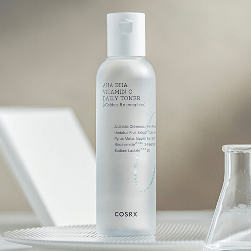 Uma garrafa COSRX Refresh AHA BHA Vitamin C Daily Toner 150ml que está em cima de uma placa branca.
