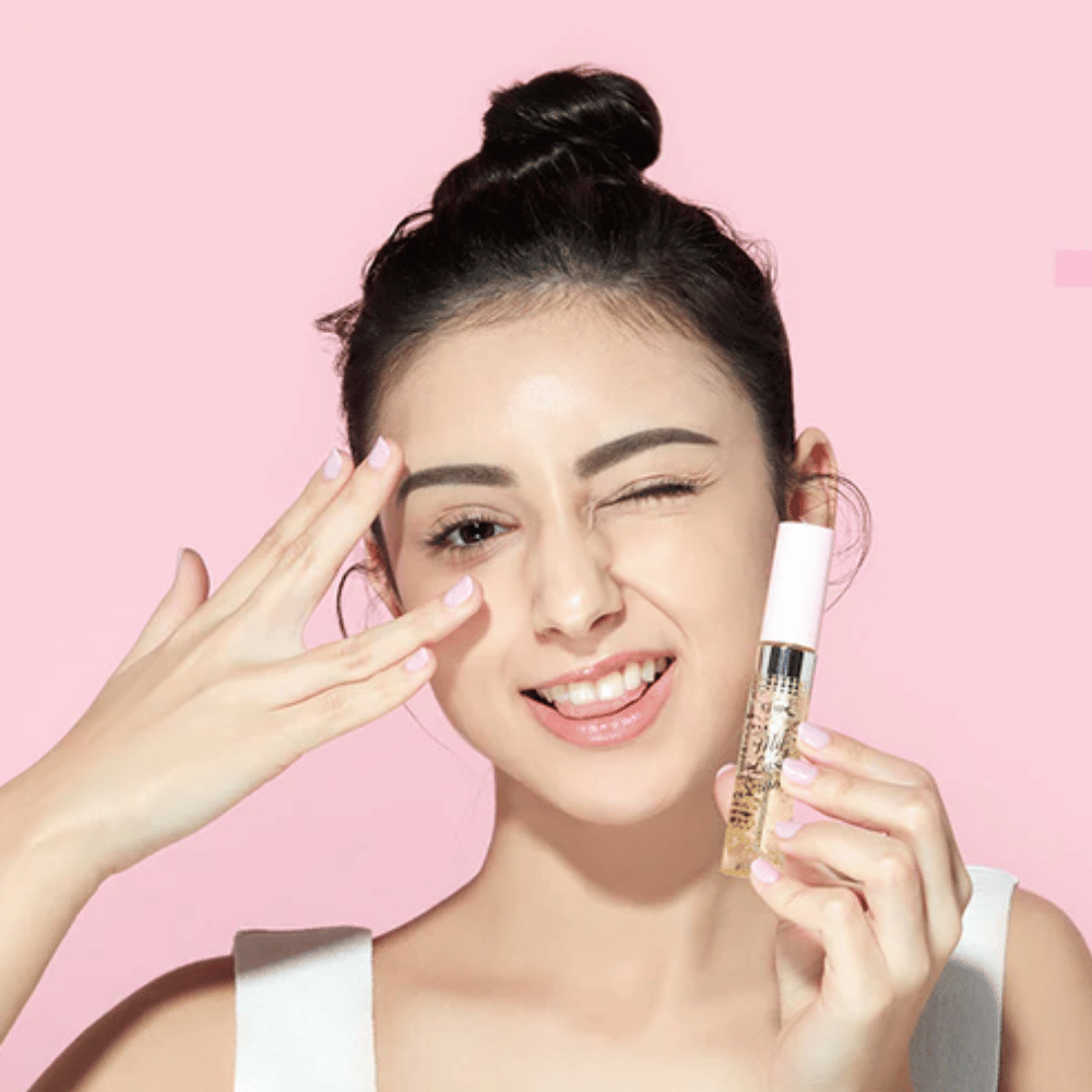 Uma mulher segura uma garrafa ETUDE My Lash Serum 9g no rosto para fortalecer os cílios.