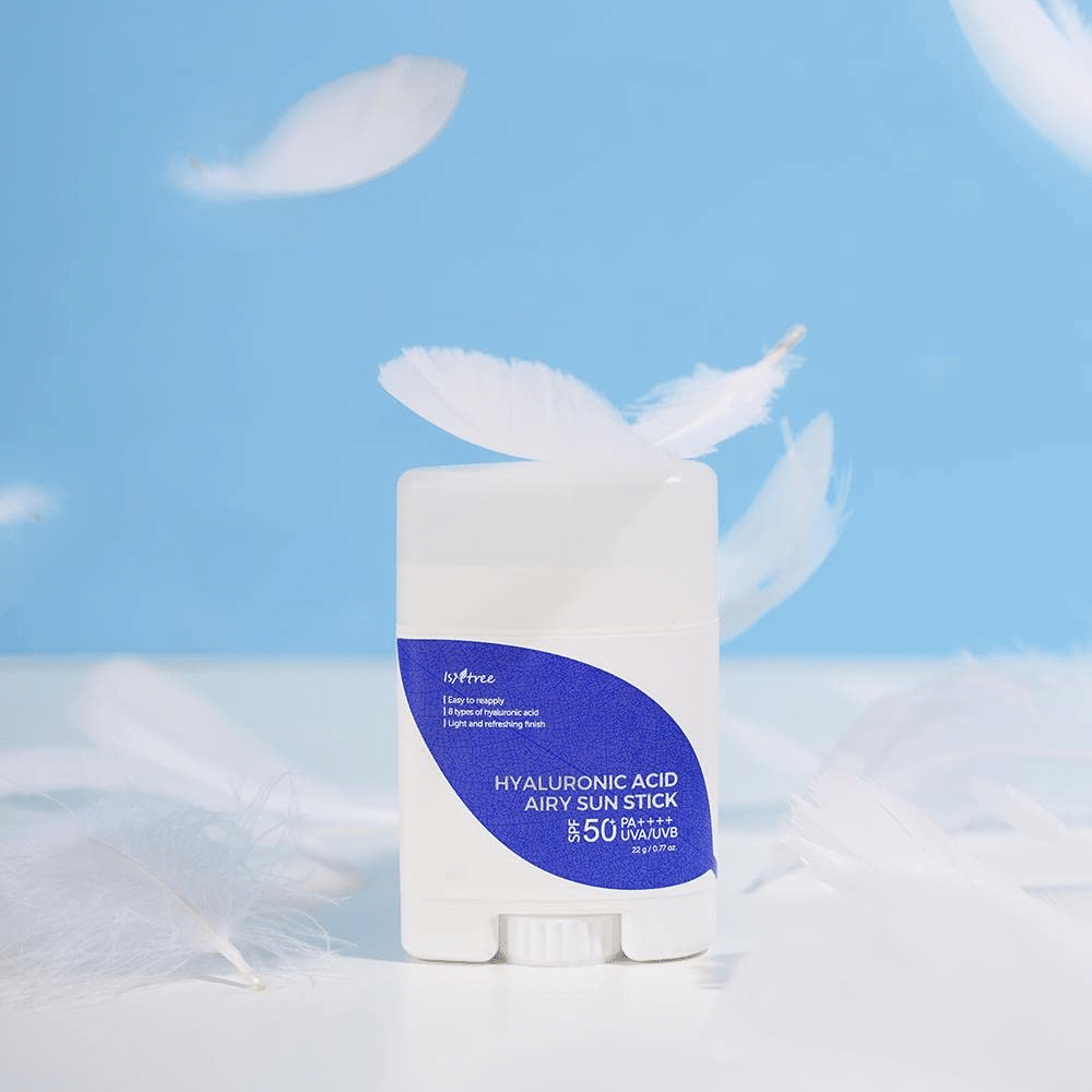 Um Isntree Hyaluronic Acid Airy Sun Stick com SPF 50+ e Ácido Hialurônico, adornado com penas brancas.