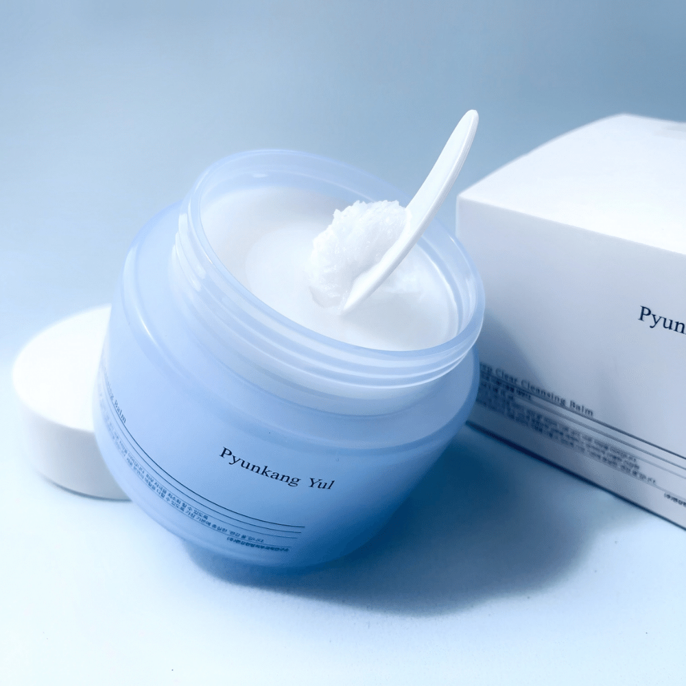 Um frasco Pyunkang Yul Deep Clear Cleansing Balm 100ml com uma colher ao lado.