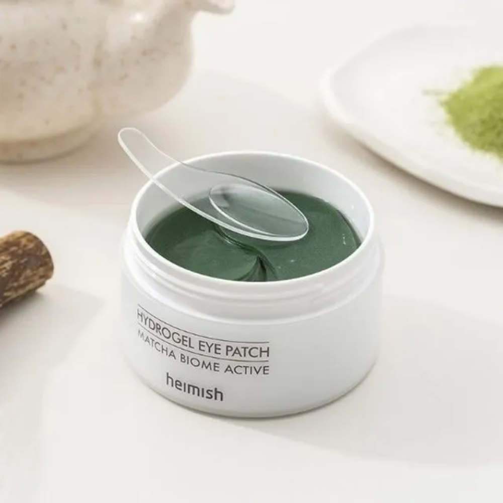 Uma tigela com Heimish Matcha Biome Hydrogel Eye Patch 60 pensos com uma colher.