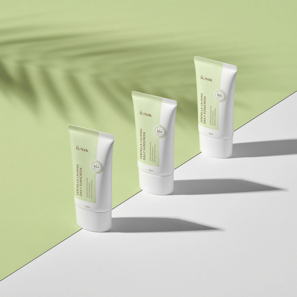 Três tubos iUNIK Centella Calming Daily Sunscreen com SPF 50+ proteção contra raios UVA e UVB sobre fundo branco.